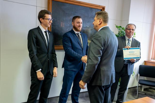 Zástupce MV ČR Jan Paďourek gratuluje výzkumníkům z FEKT | Autor: Nikola Číková