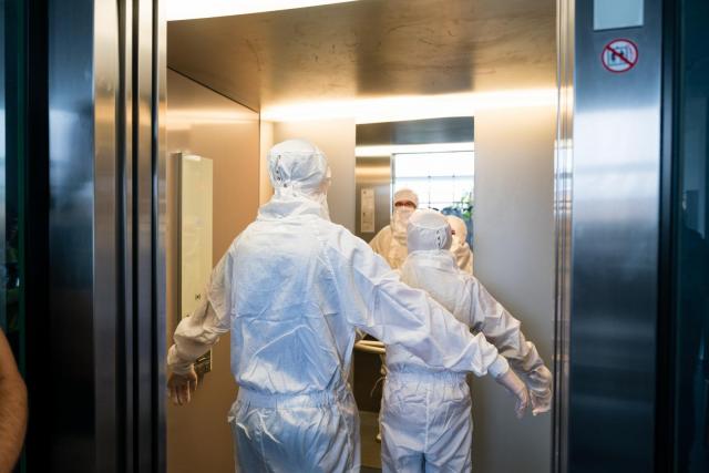 Do laboratoří musí lidé vstupovat ve speciálních ochranných oblecích. | Autor: Václav Koníček